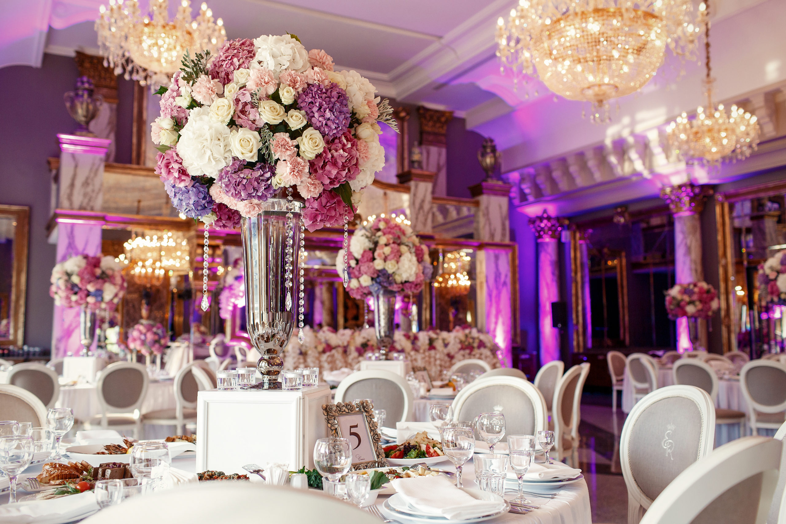 Table number 5 decorated with pink and violet hydrangeas and served with sparkling glassware